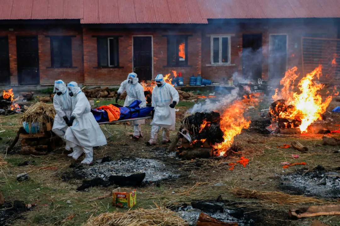  Members of Nepal Army in personal protective equipment (PPE) carry a body of a person, who died from the coronavirus disease (COVID-19), at the crematorium, in Kathmandu, Nepal May 11, 2021. REUTERS/Navesh Chitrakar     TPX IMAGES OF THE DAY 