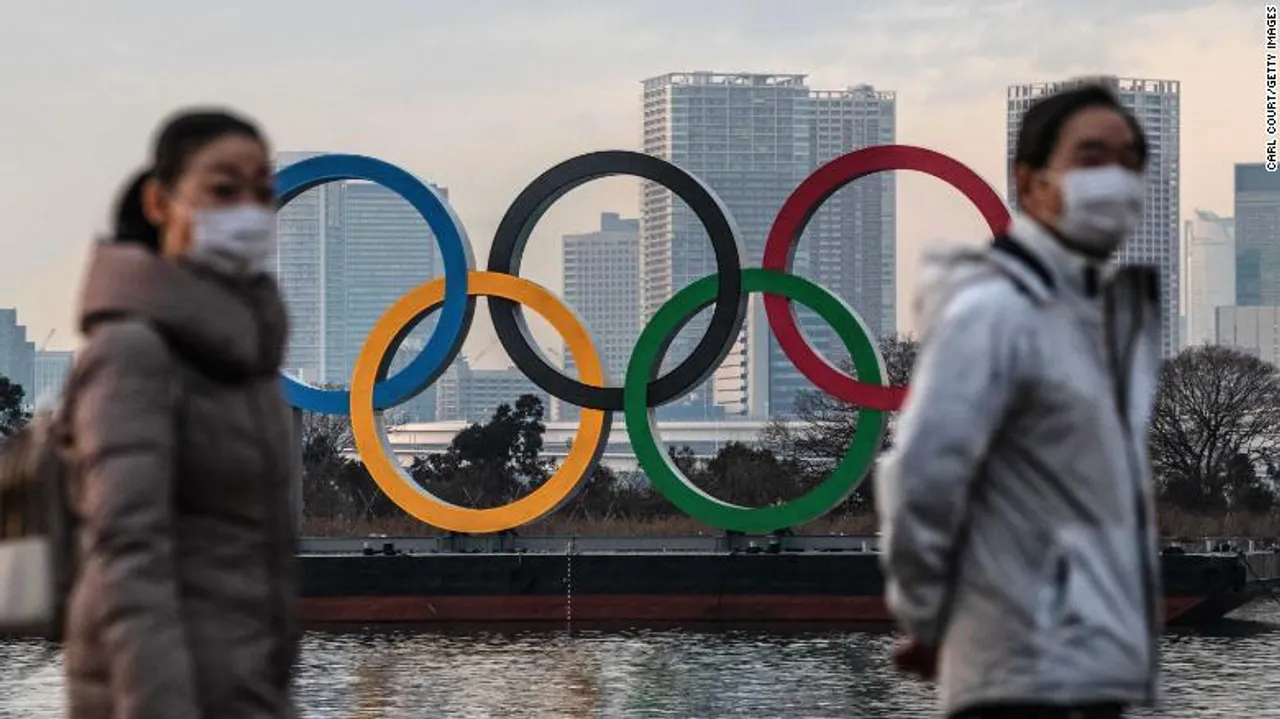  TOKYO, JAPAN - JANUARY 22: People wearing face masks walk past the Olympic Rings on January 22, 2021 in Tokyo, Japan. With just six months to go until the start of the Games, it has been reported that the Japanese authorities have privately concluded that the Olympics could not proceed due to the ongoing Covid-19 coronavirus pandemic. Spokesmen from the IOC and Japanese government have since rejected the report. (Photo by Carl Court/Getty Images) 