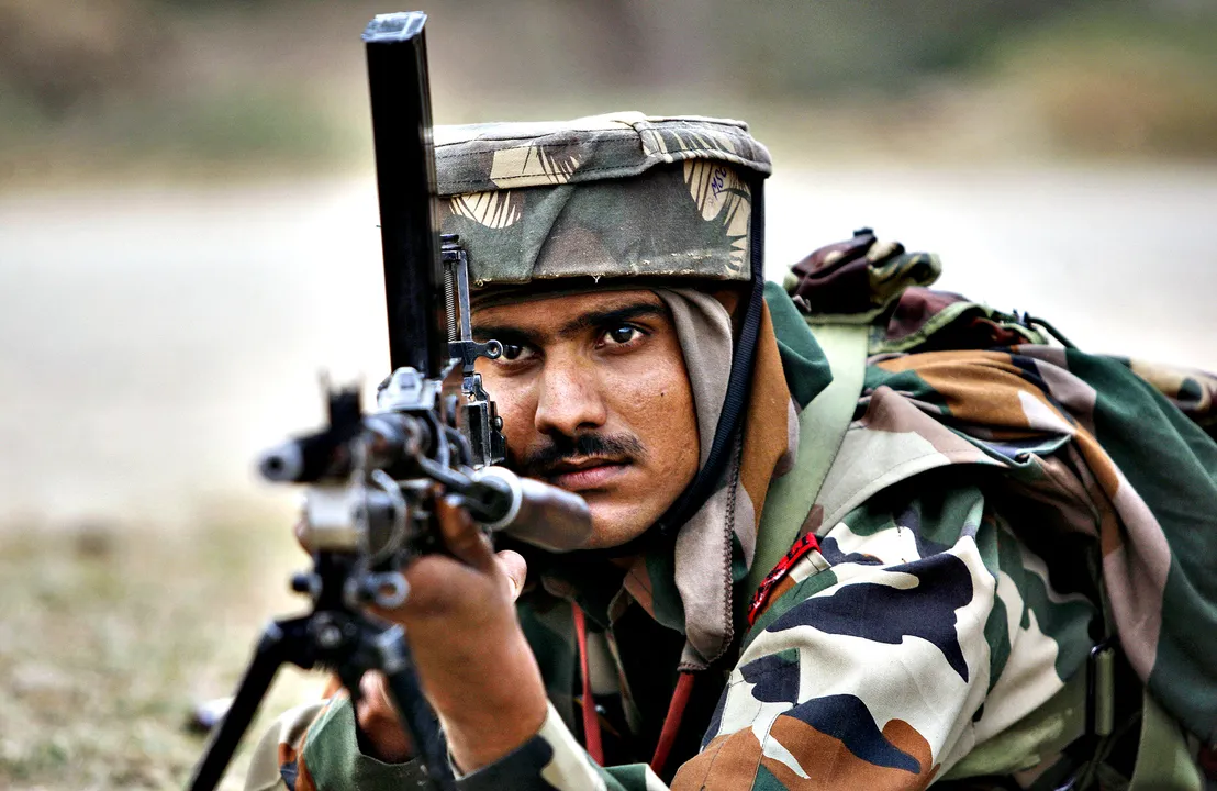  An Indian Army soldier takes position during an encounter with armed suspected militants at Pindi Khattar village in Arnia border sector, 43 kilometers (27 miles) south of Jammu, India, Thursday, Nov. 27, 2014. An army officer says some of the militants occupied an abandoned bunker in Jammu region early Thursday and fired at the soldiers in Arnia sector in the Indian portion of Kashmir. (AP Photo/Channi Anand) 