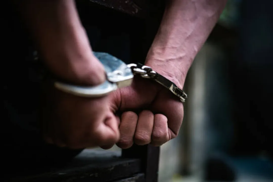  Man on the chair in Handcuffs. Rear view and Closeup ,Men criminal in handcuffs arrested for crimes. With hands in back,boy  prison shackle in the jail violence concept. 