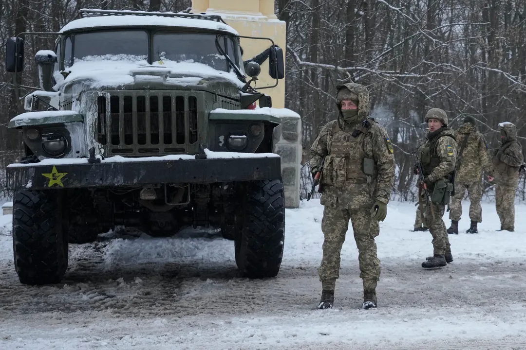  Ukrainian servicemen stand by a deactivated Russian military multiple rocket launcher on the outskirts of Kharkiv, Ukraine, Friday, Feb. 25, 2022. Russian troops bore down on Ukraine's capital Friday, with gunfire and explosions resonating ever closer to the government quarter, in an invasion of a democratic country that has fueled fears of wider war in Europe and triggered worldwide efforts to make Russia stop. (AP Photo/Vadim Ghirda) 