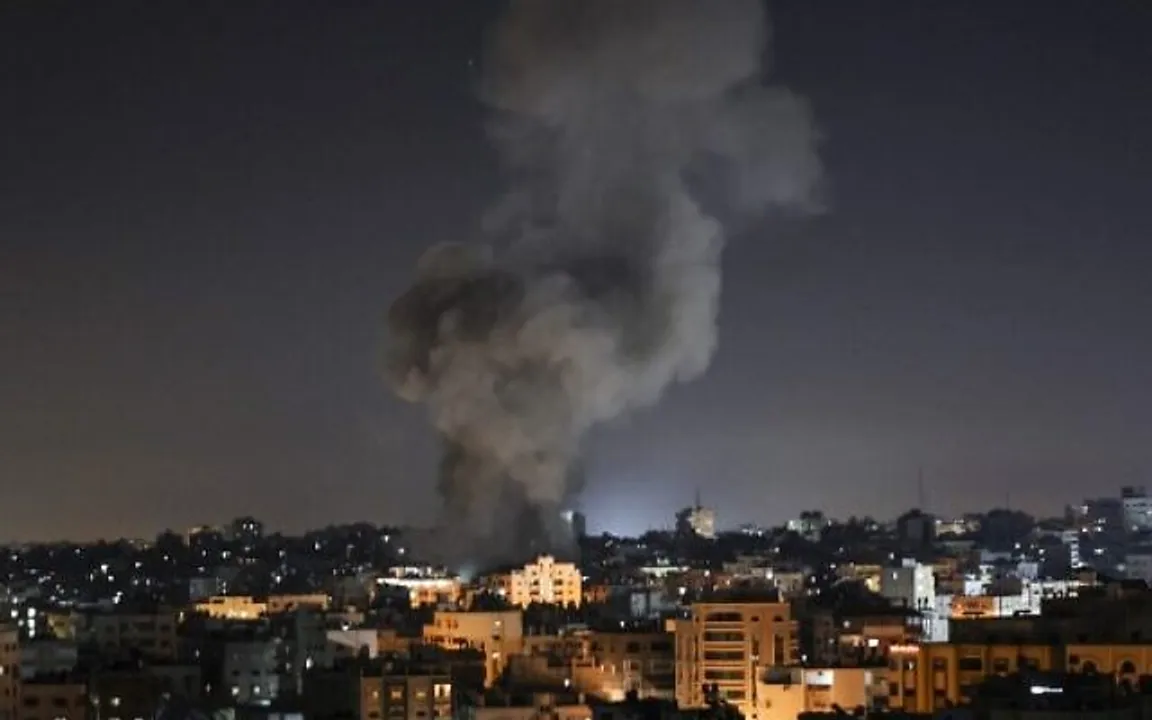  Smoke billows above buildings after an Israeli airstrike on Gaza City in the Gaza Strip early on May 15, 2021. - Israel faced a widening conflict on May 14, as deadly violence erupted across the West Bank amid a massive aerial bombardment in Gaza and unprecedented unrest among Arabs and Jews inside the country. (Photo by MAHMUD HAMS / AFP) 
