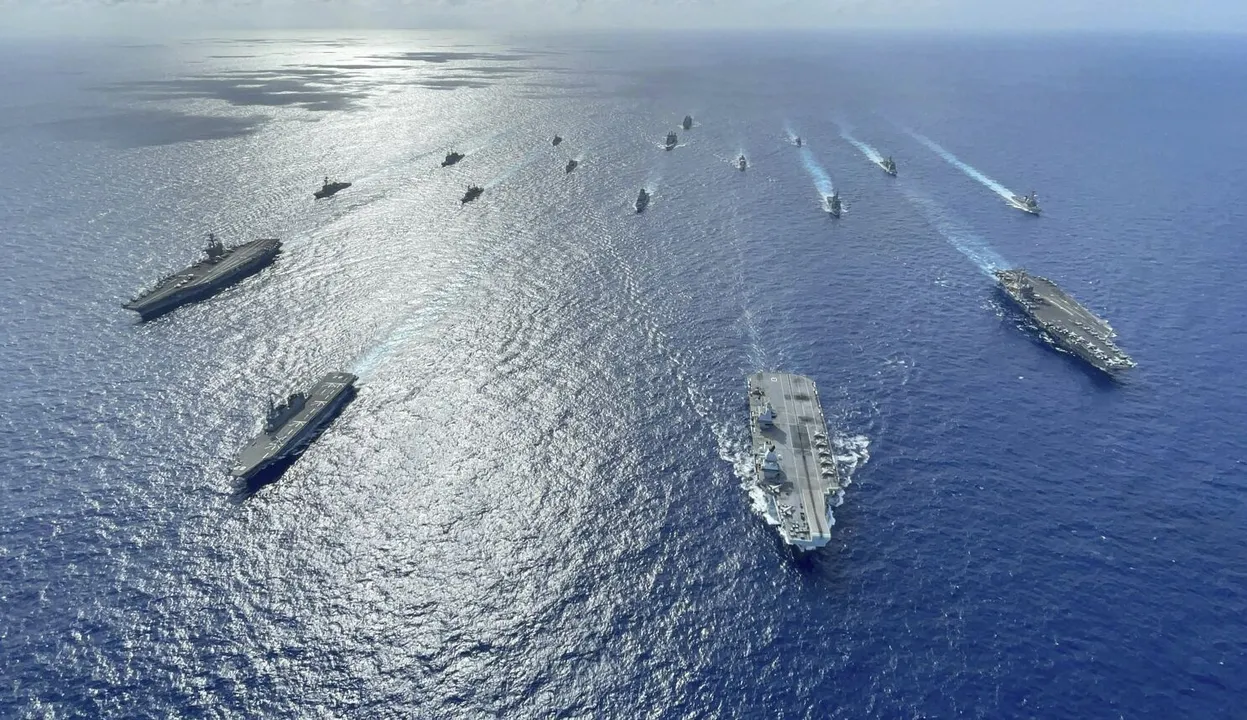  In this photo released by the U.S. Indo-Pacific Command, the United Kingdom's carrier strike group led by HMS Queen Elizabeth (R 08), and Japan Maritime Self-Defense Forces led by (JMSDF) Hyuga-class helicopter destroyer JS Ise (DDH 182) joined with U.S. Navy carrier strike groups led by flagships USS Ronald Reagan (CVN 76) and USS Carl Vinson (CVN 70) sails to conduct multiple carrier strike group operations in the Philippine Sea, Oct. 3, 2021. A spate of recent Chinese military flights off Taiwan, which Beijing claims as its own, and naval maneuvers by the United States and its allies to reinforce maritime routes challenged by China are fueling increasing tensions in a region already on edge. (Gray Gibson/U.S. Navy via AP) 