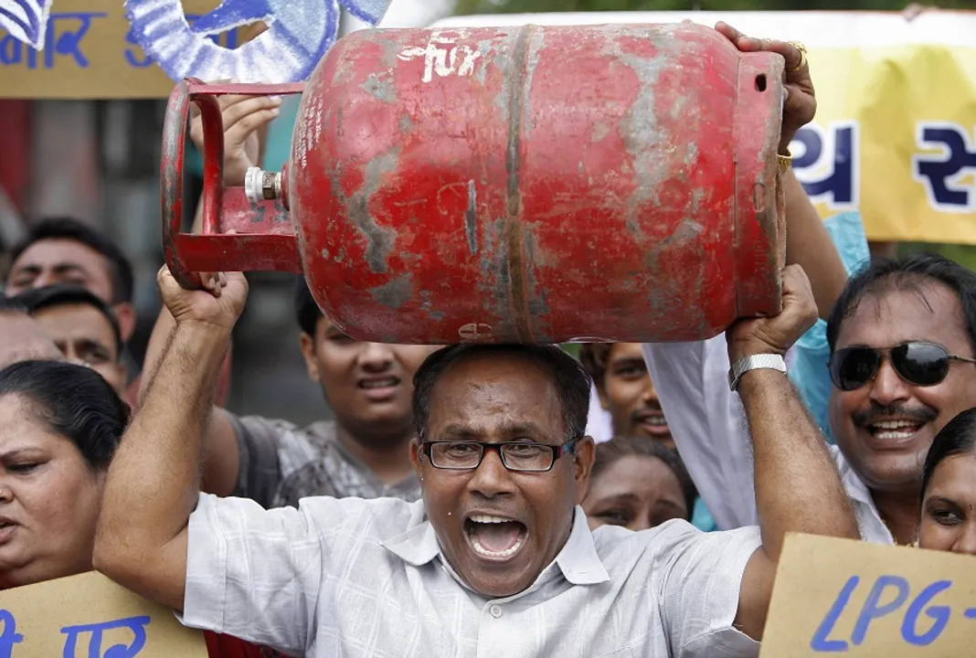  A social activist from the fight against corruption group holds a liquefied petroleum gas (LPG) cylinder during protest against rise in fuel prices in the western Indian city of Ahmedabad September 14, 2012. India's beleaguered government appeared poised on Friday to push ahead with measures to revive the economy after months of dithering, even as it came under heavy fire from allies and opponents alike for raising heavily subsidized fuel prices. REUTERS/Amit Dave (INDIA - Tags: ENERGY BUSINESS CIVIL UNREST POLITICS) 