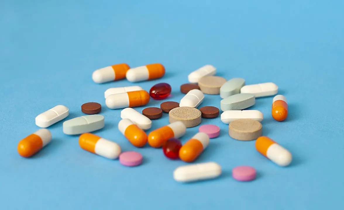  pills are scattered on a blue background close-up 