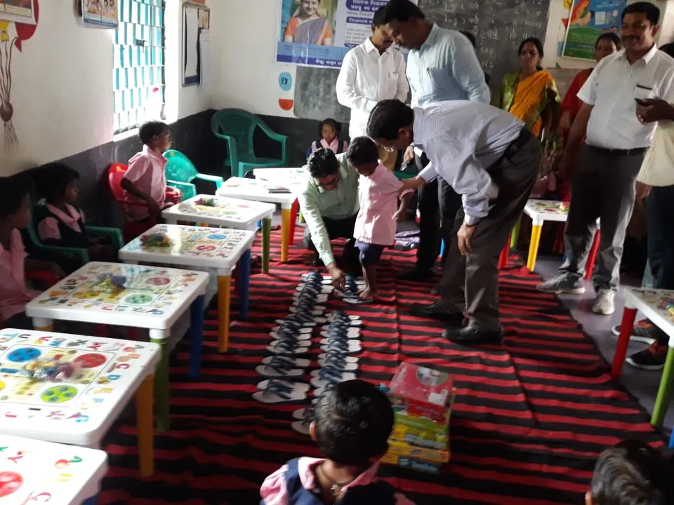  Watch: Odisha Collector helps Anganwadi students wear slippers