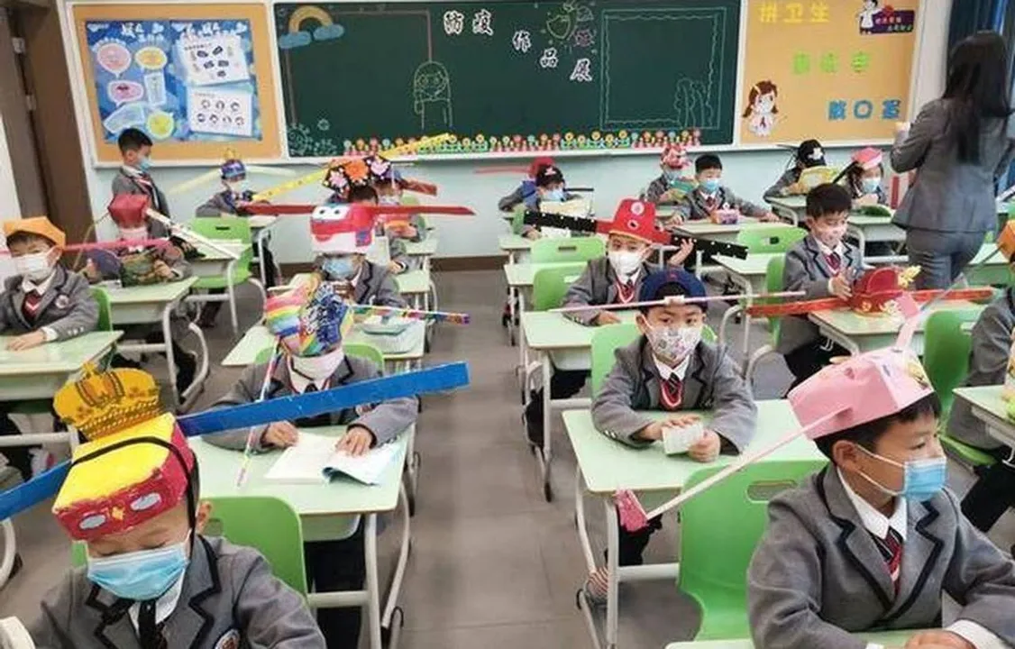  Students wear unique headgear in China to keep social distancing in class