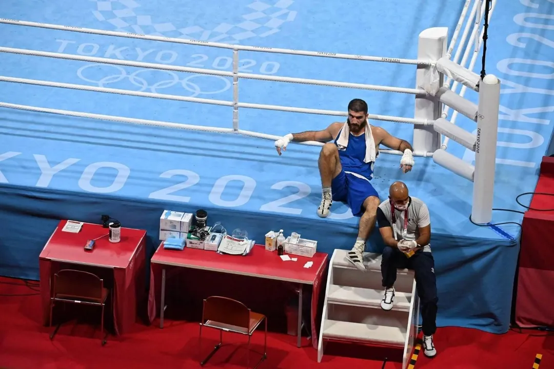  French boxer disqualified for headbutt, sits on ringside in protest. 