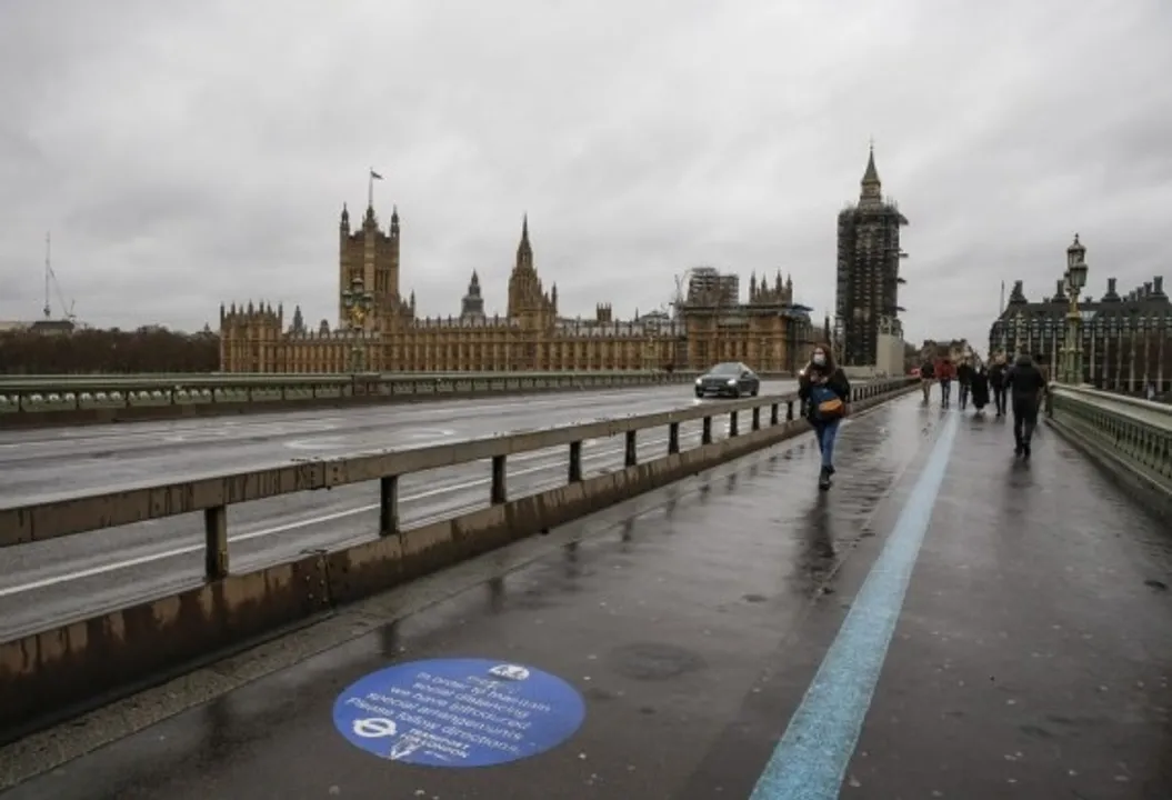  People walk in front of the Houses of Parliament in London, Britain, Dec. 13, 2020.  (Xinhua/Han Yan) 
