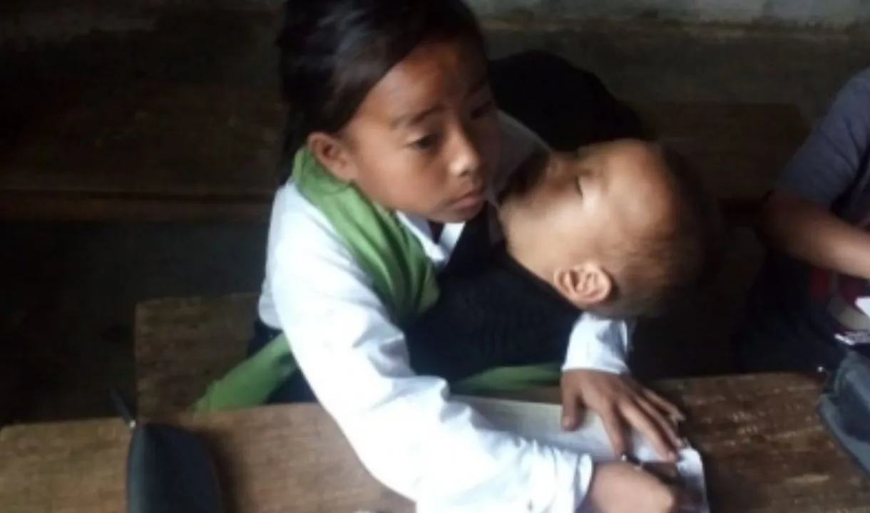  Manipur's 10-yr-old girl attends classes while babysitting sister in lap
