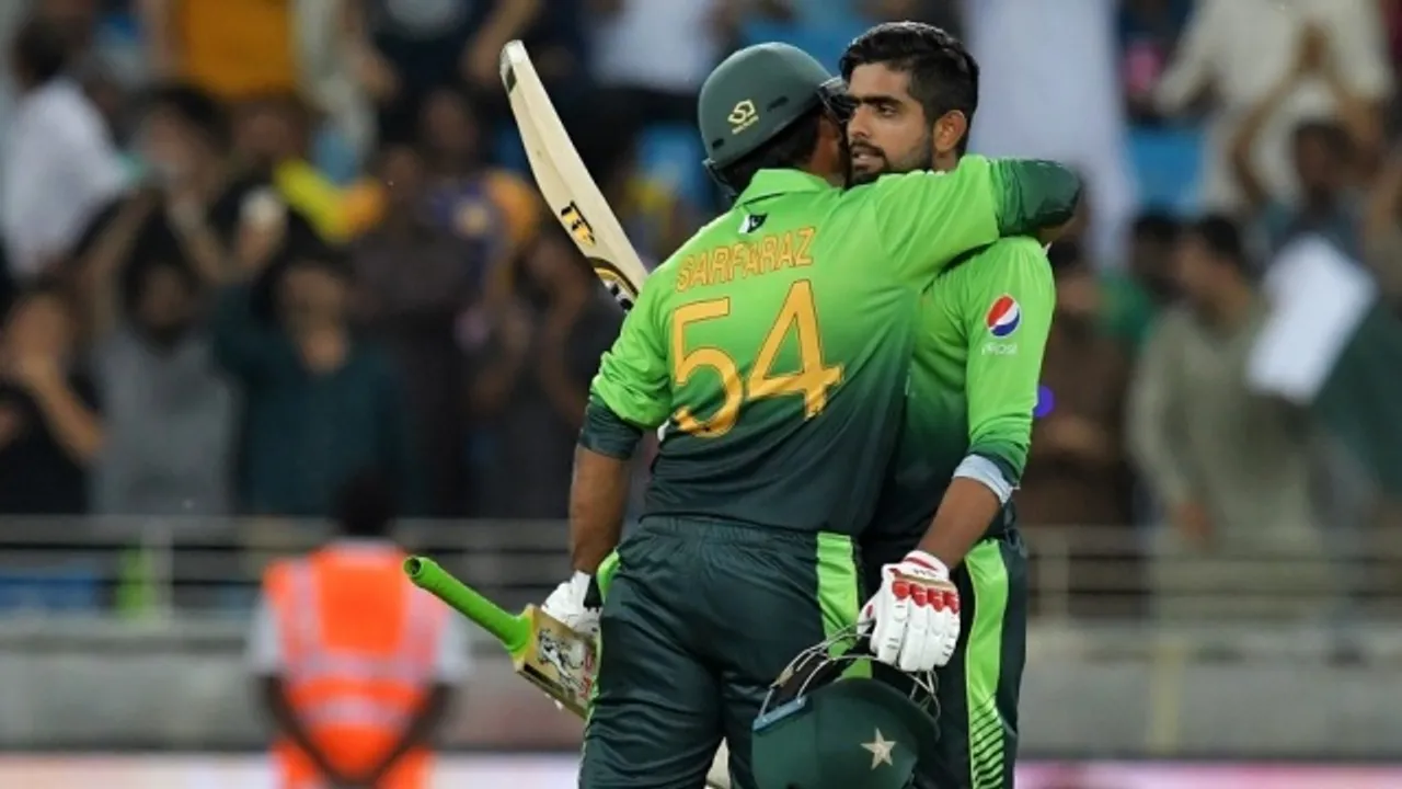  Pakistan's Babar Azam (R) celebrates 100 runs with Pakistan's Sarfraz Ahmed  during the first one day international (ODI) cricket match between Sri Lanka and Pakistan at Dubai International Stadium in Dubai on October 13, 2017. / AFP PHOTO / GIUSEPPE CACACE 