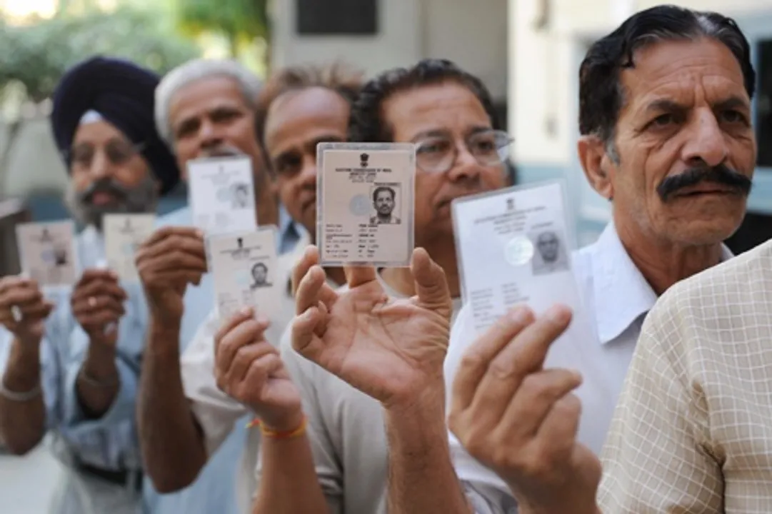  Indian voters hold up their voter ID cards as they stand in a queue to cast their vote at a polling station in Amritsar on May 13, 2009. during the final phase of polling for national elections.  India voters cast their final ballots in the country's marathon elections, with analysts predicting a shaky coalition government that will struggle to survive a full term.   AFP PHOTO /NARINDER NANU (Photo credit should read NARINDER NANU/AFP/Getty Images) 