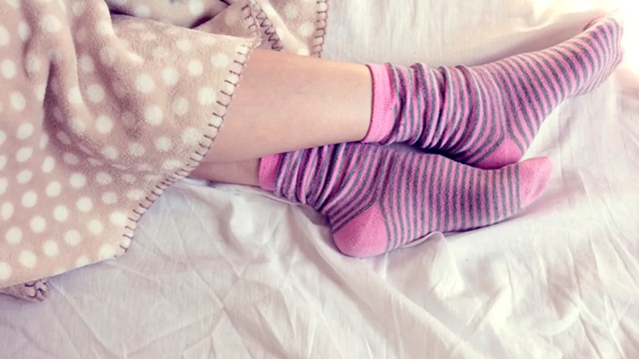  girl with pink striped socks, sleeping in bed 