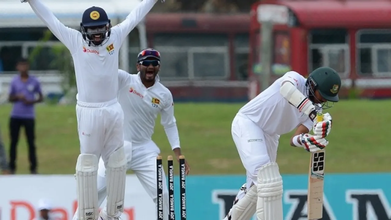  Sri Lankan wicketkeeper Niroshan Dickwella (L) and Dimuth Karunaratne (C) celebrates after he dismissed Bangladesh cricketer Soumya Sarkar (R) during the final day of the opening Test match between Sri Lanka and Bangladesh at the Galle International Cricket Stadium in Galle on March 11, 2017. / AFP PHOTO / LAKRUWAN WANNIARACHCHI 