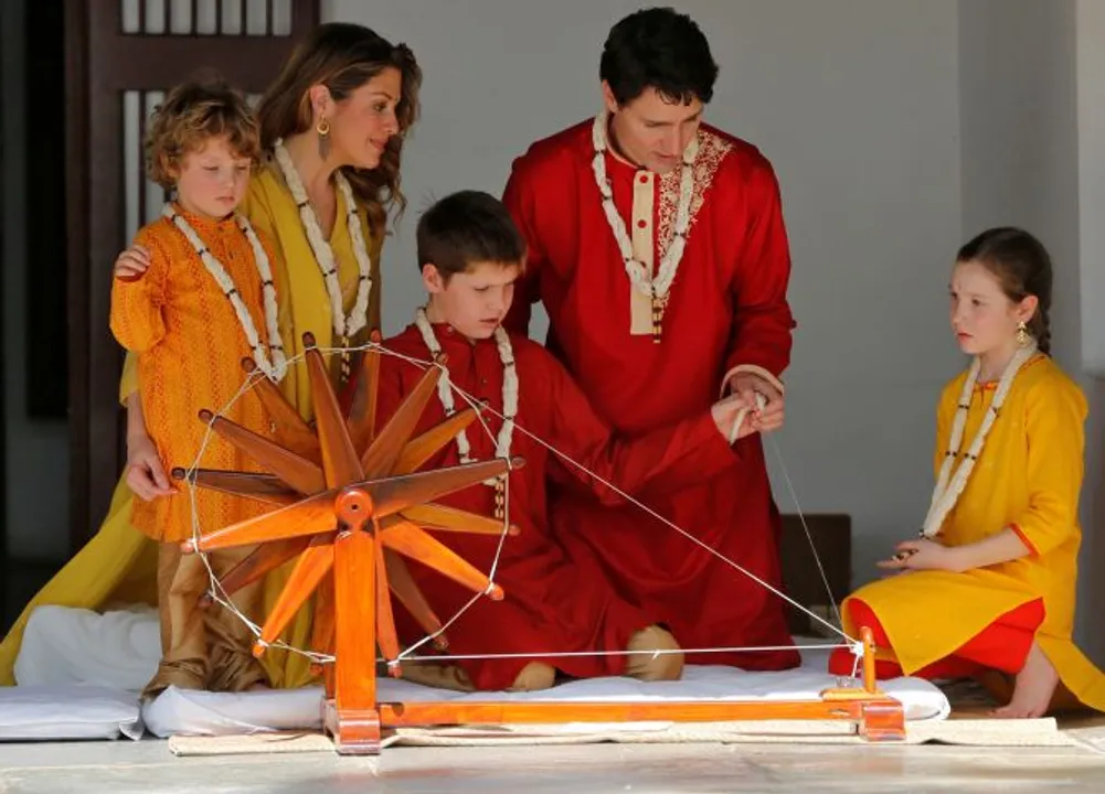  Canadian Prime Minister Justin Trudeau and his son Xavier spin cotton on a wheel watched by Trudeau's wife Sophie Gregoire Trudeau, their daughter Ella Grace and son Hadrien during their visit to Gandhi Ashram in Ahmedabad, India, February 19, 2018. REUTERS/Amit Dave - RC1234987AB0 