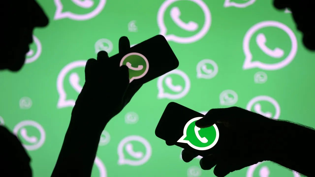  Men pose with smartphones in front of displayed Whatsapp logo in this illustration September 14, 2017. REUTERS/Dado Ruvic - RC1754A449A0 