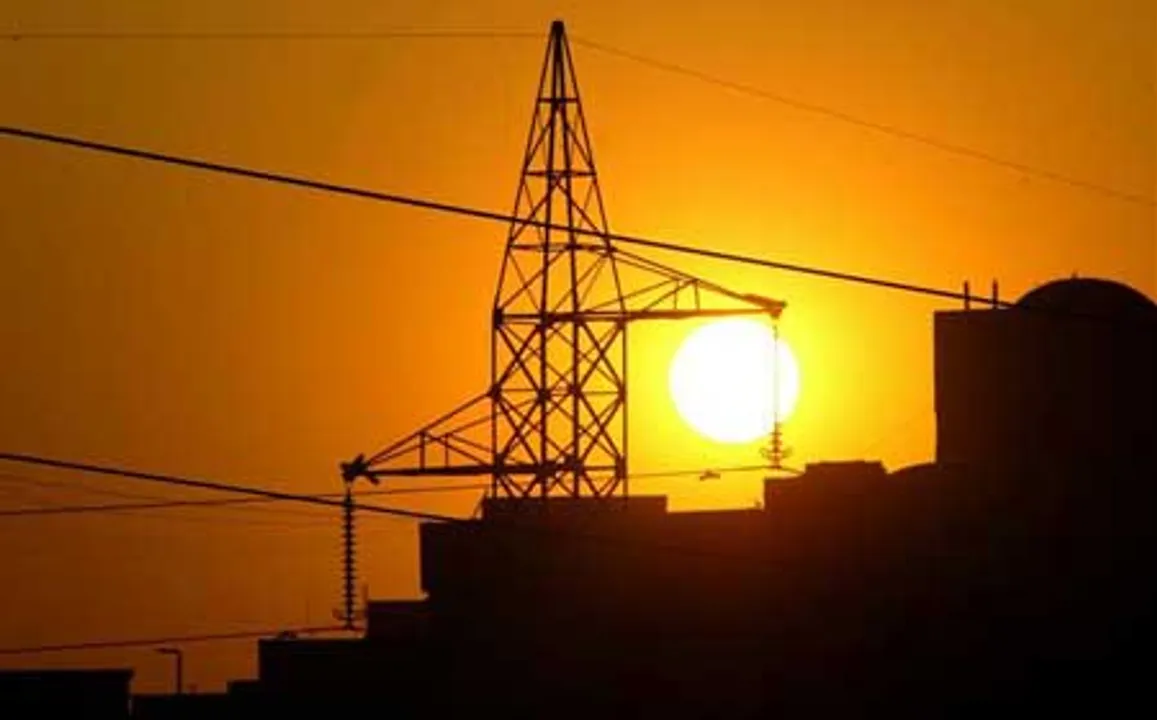  Sun sets behind a power tower near a building in New Delhi February 4, 2006. REUTERS/Kamal Kishore/Files 