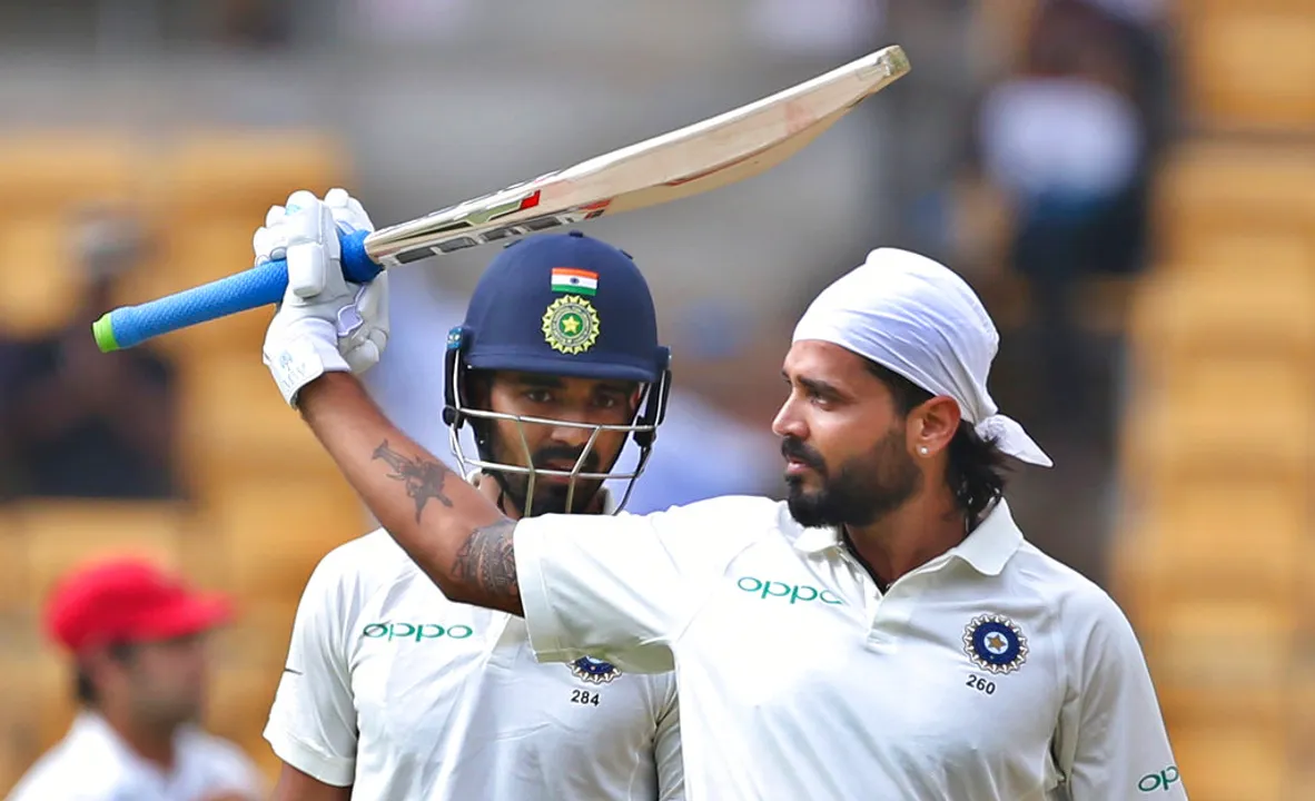  India's Lokesh Rahul, left, watches teammate Murali Vijay raise his bat to celebrate scoring a century during the one-off cricket test match against Afghanistan in Bangalore, India, Thursday, June 14, 2018. (AP Photo/Aijaz Rahi) 