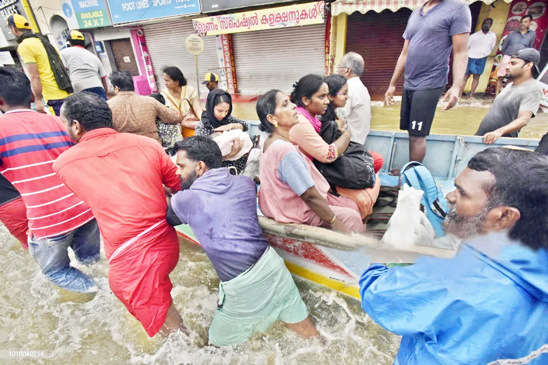  PATHANAMTHITTA, INDIA - AUGUST 18: Local fishermen, volunteers and rescue personnel evacuate residents through a boat due to floods at Panadala, on August 18, 2018 in district Pathanamthitta, India. The flooding, described by the chief minister as the worst in nearly a century, began shortly after August 8 when a spell on unusually heavy rain began. In this period, nearly 222 people have died and around 350,000 have been taken to relief camps. Officials said 67 helicopters, 24 aeroplanes and 548 motorboats have fanned out across Kerala in what has turned into one of the biggest rescue operations to be carried out in India.  (Photo by Raj K Raj/Hindustan Times via Getty Images) 