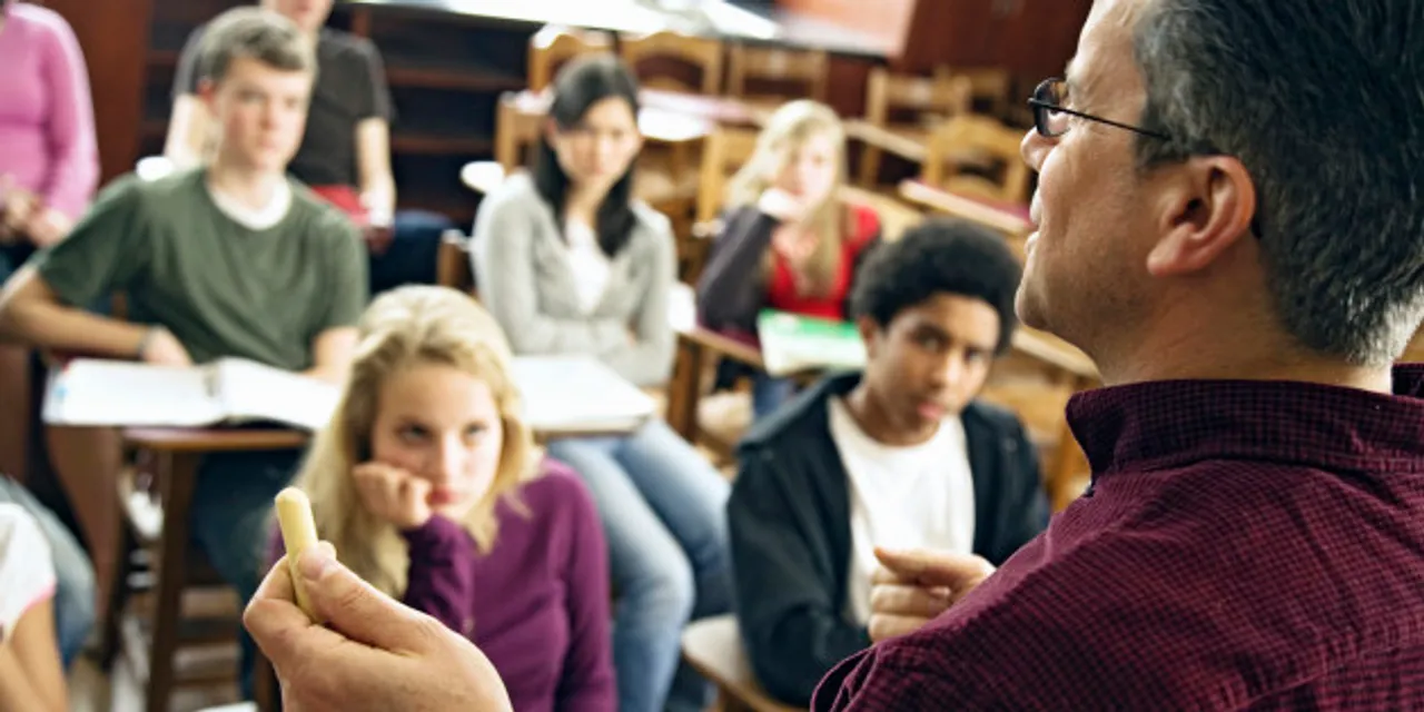  Over the shoulder view of students listening to teacher 
