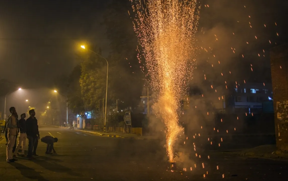 Revelers watch a firework during Diwali celebrations in Delhi, India, on Wednesday, Nov. 11, 2015. Diwali, the Hindu Festival of lights, sees shops and homes festooned with decorations. Fireworks shake the skies above luxury homes and slums alike, while the shopping rush is so fierce that gold prices move. Photographer: Prashanth Vishwanathan/Bloomberg 