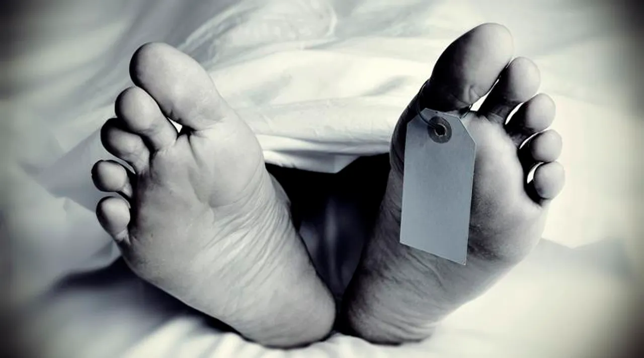 closeup of the feet of a dead body covered with a sheet, with a blank tag tied on the big toe of his left foot, in monochrome, with a vignette added 