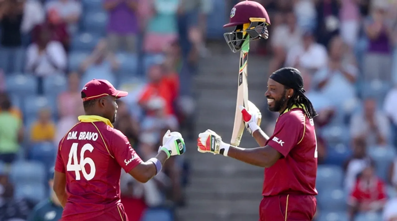  St. George's :West Indies' Chris Gayle, right, celebrates with teammate Darren Bravo after hitting a six to reach 10.000 ODIs runs in his career during the fourth One Day International cricket match against England at the National Stadium in St. George's, Grenada, Wednesday, Feb. 27, 2019. AP/PTI(AP2_28_2019_000033B) 