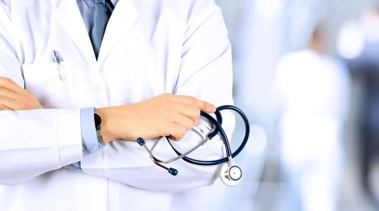  Portrait an unknown male doctor holding a stethoscope behind 