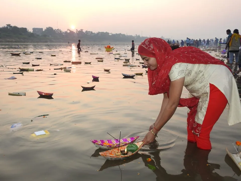  କୁଆଖାଇ ନଦୀରେ ଶ୍ରଦ୍ଧାର ସହ ଡଙ୍ଗା ଭସାଉଛନ୍ତି ଜଣେ ଯୁବତୀ।