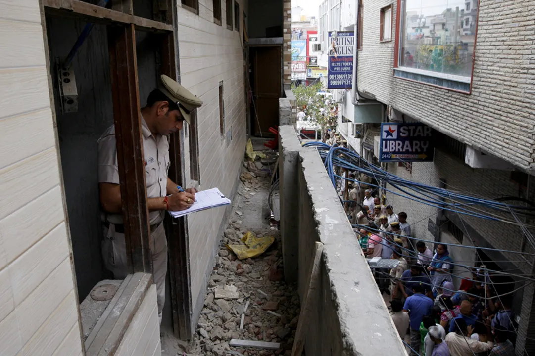  A policeman writes notes in the house where the bodies of eleven members of a family were found dead in Burari, in New Delhi, India, July 1, 2018. REUTERS/Stringer - RC1BF1DFF710 