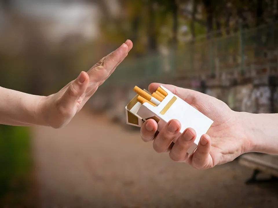 Quitting smoking concept. Hand is rejecting cigarette offer. 