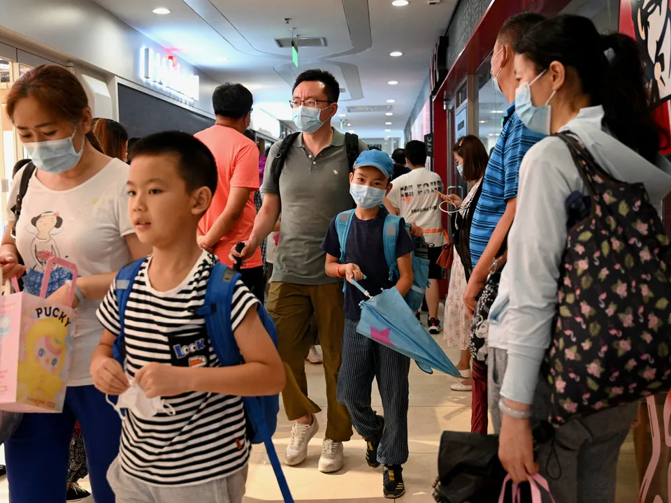  This picture taken on July 29, 2021rrrrrrrrrr, shows students and parents walking after attending a private after-school education in Haidan district of Beijing. - In Beijing's Haidian district where homes go for millions and competition is cutthroat for a spot in top schools, parents say sudden curbs on private after-school education are misplaced while the competition facing their kids is so tough. - TO GO WITH AFP STORY: China-education-economy, by Beiyi SEOW (Photo by NOEL CELIS / AFP) / TO GO WITH AFP STORY: China-education-economy, by Beiyi SEOW (Photo by NOEL CELIS/AFP via Getty Images) 