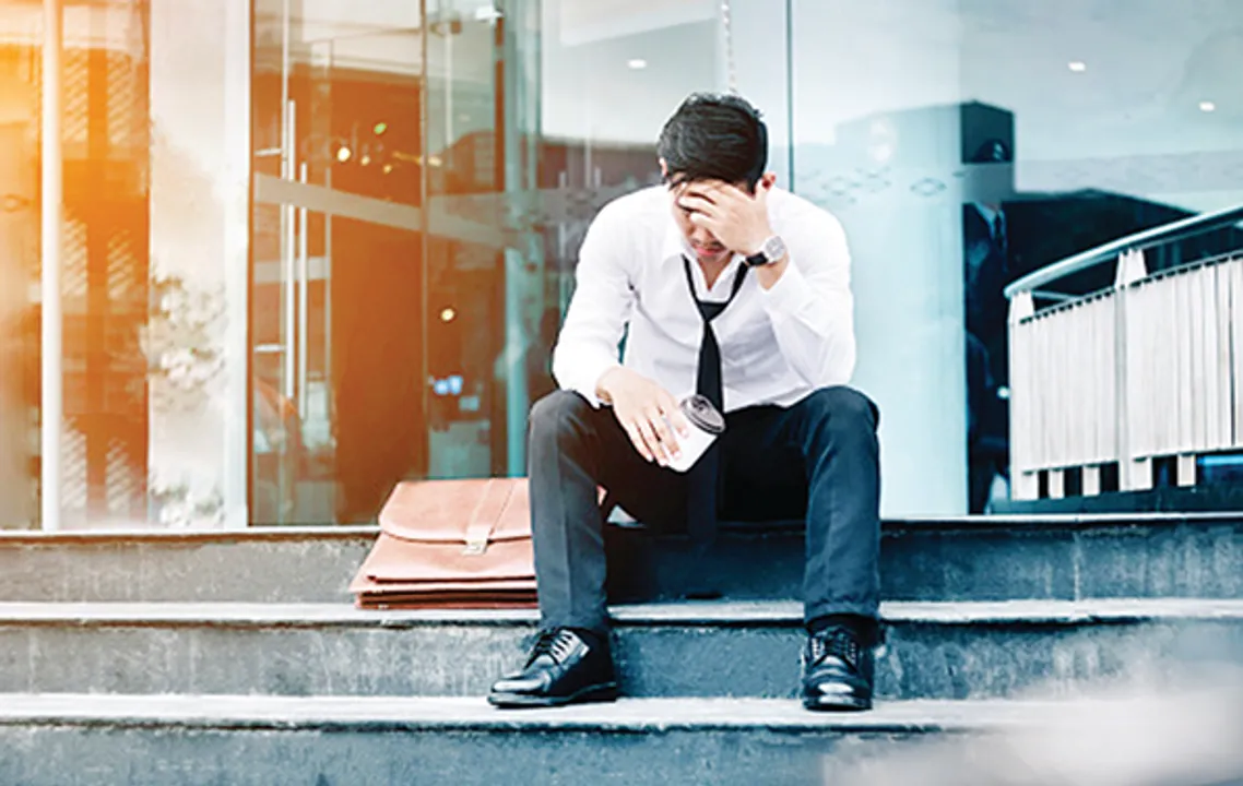  Unemployed Tired or stressed businessman sitting on the walkway after work Stressed businessman concept 