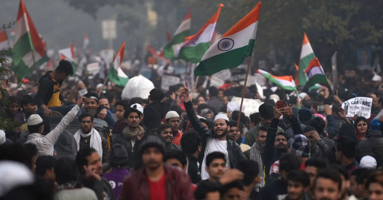  NEW DELHI, INDIA - DECEMBER 20: People hold national flag during a protest against the new citizenship law, which was recently passed in both houses of the parliament, at Jamia Millia Islamia University on December 20, 2019 in New Delhi, India. The act seeks to grant Indian citizenship to refugees from Hindu, Christian, Sikh, Buddhist and Parsi communities fleeing religious persecution from Pakistan, Afghanistan, and Bangladesh, and who entered India on or before December 31, 2014. The Parliament had passed the Citizenship (Amendment) Bill, 2019 last week and it became an act after receiving assent from President Ram Nath Kovind. Since then, protests including some violent ones have erupted in various regions of the country, including the North East over the amended citizenship law.(Photo by Burhaan Kinu/Hindustan Times via Getty Images) 