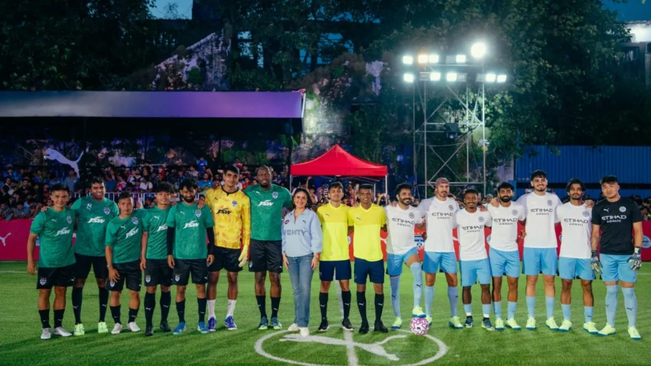 Usain Bolt (wearing a blue and red jersey) playing football with other players in a 5v5 match; Kareena Kapoor Khan is on the sideline; PUMA India logo is visible.
