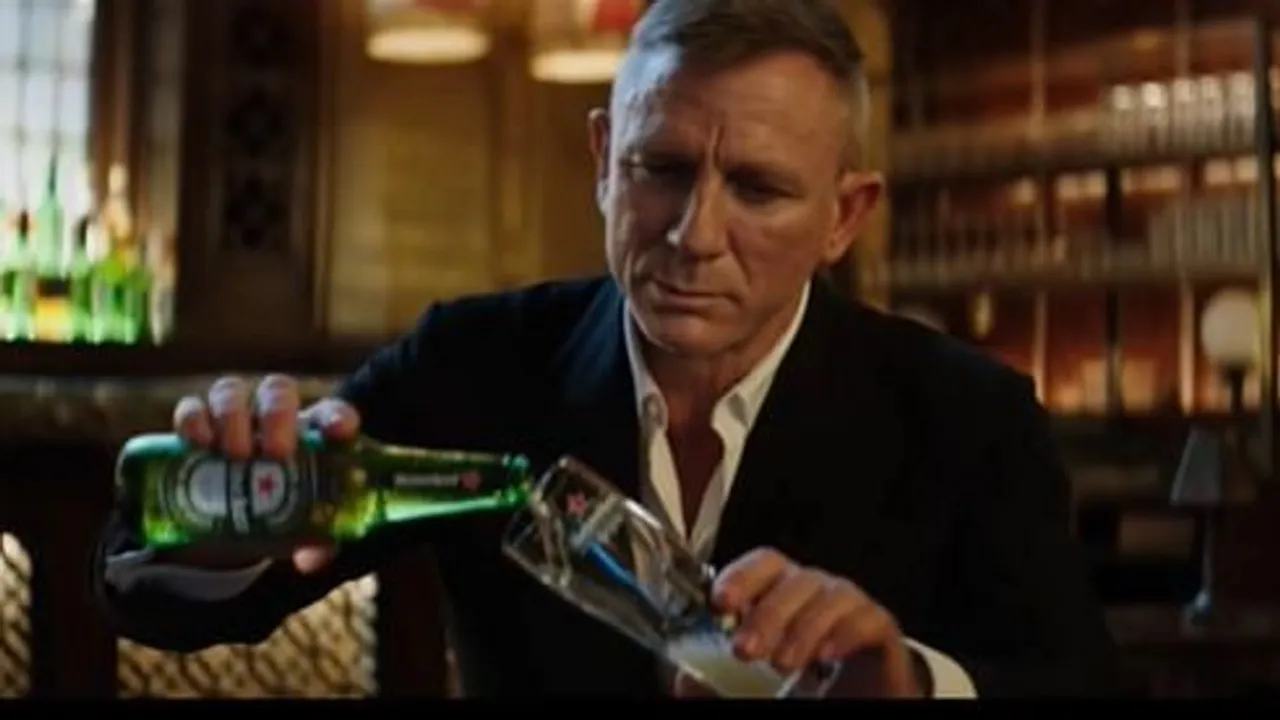James Bond pours a Heineken while waiting for his flick to hit the screens