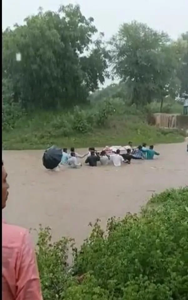 বন্যার মধ্যে মৃতদেহ কাঁধে নিয়ে হাঁটছেন মানুষ, ভাইরাল ভিডিও