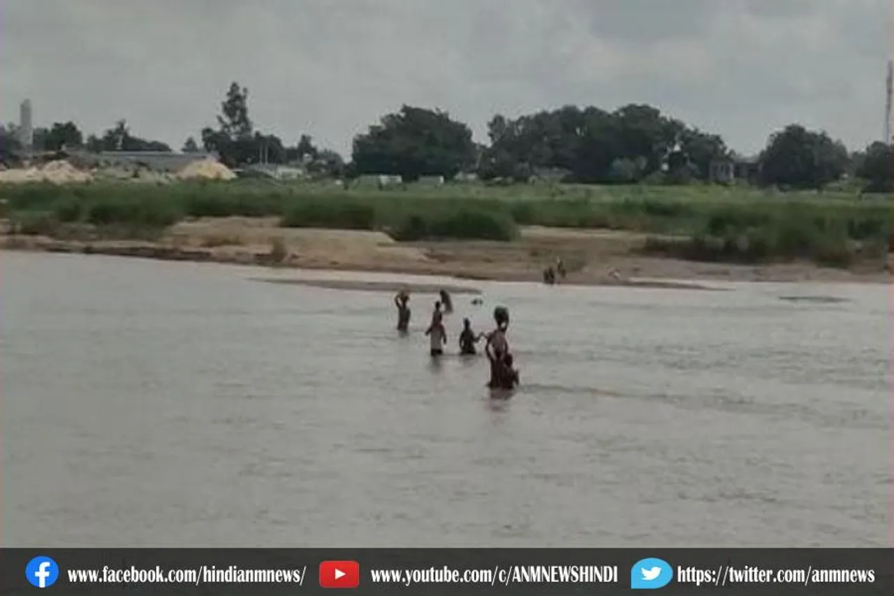 हाथ में जान की बाजी लगाकर नदी पार (वीडियो)