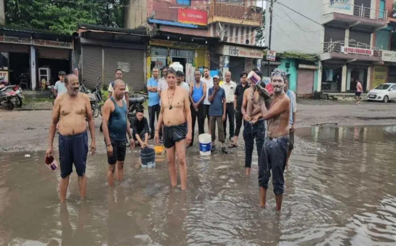 कोरबा में सड़क पर गड्ढों और जलभराव से व्यापारी परेशान: अनोखे तरीके से किया प्रदर्शन, रोड पर भरे पानी में लगाई डुबकी