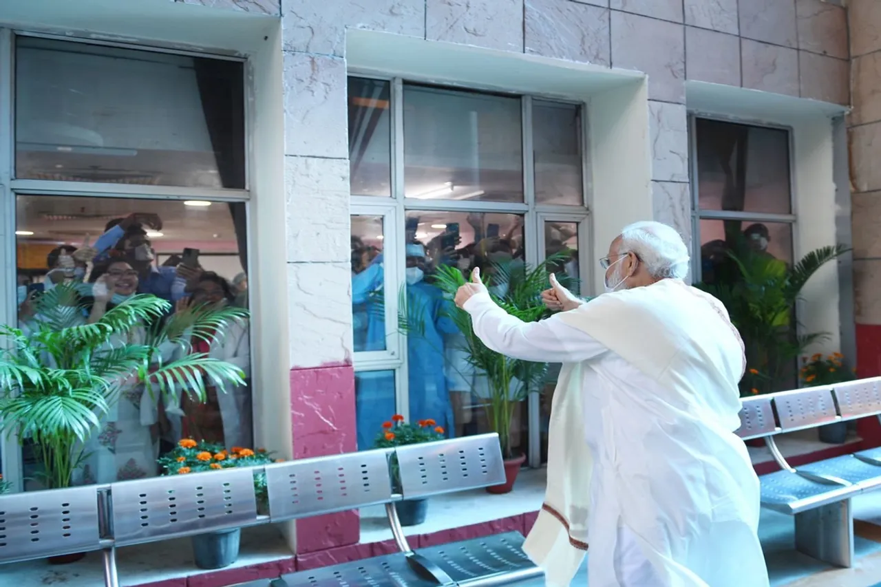 Prime Minister Narendra Modi gives a thumbs up to healthcare workers at Delhi's RML Hospital today morning as India crosses one billion COVID19 vaccinations
