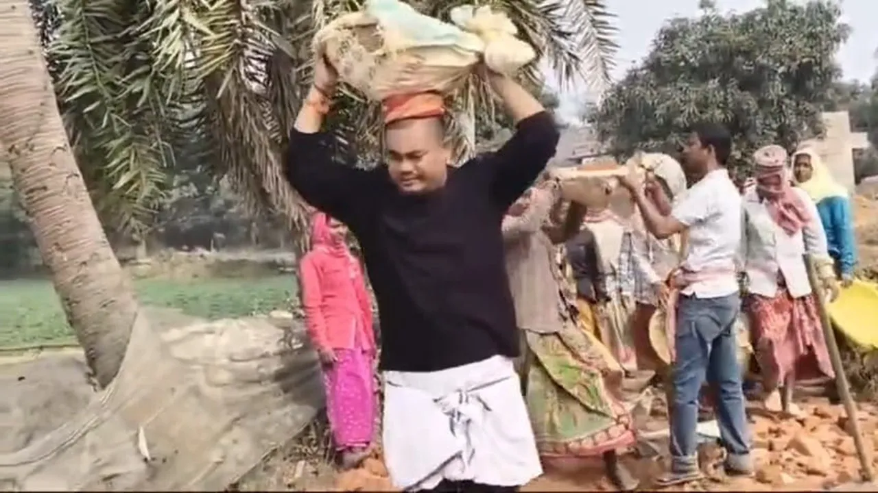 BJP MLA Chinmoy Deb Barman  ,Malda Gajol News,  MLA Repairing Road Viral Video,  TMC vs BJP West Bengal  ,Gajol Assembly Constituency,  Political Drama Malda  ,Patal Singh Village Road,  West Bengal Politics  ,BJP Development Work Controversy,বিজেপি বিধায়ক চিম্ময় দেব বর্মন,  গাজোল মালদহ  ,বিধায়কের রাস্তা সারাই , মাথায় ইটের বস্তা  ,ভাইরাল ভিডিও,  তৃণমূল বিজেপি তরজা  ,পাতাল সিং গ্রাম  ,বেহাল রাস্তা সংস্কার  ,পশ্চিমবঙ্গ রাজনীতি