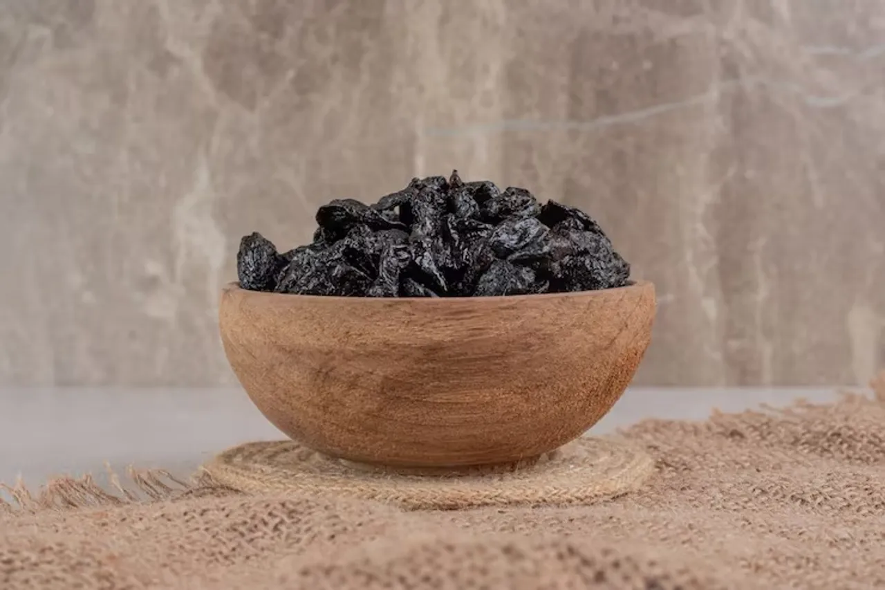 dry-black-plums-wooden-cup-piece-burlap_114579-25286