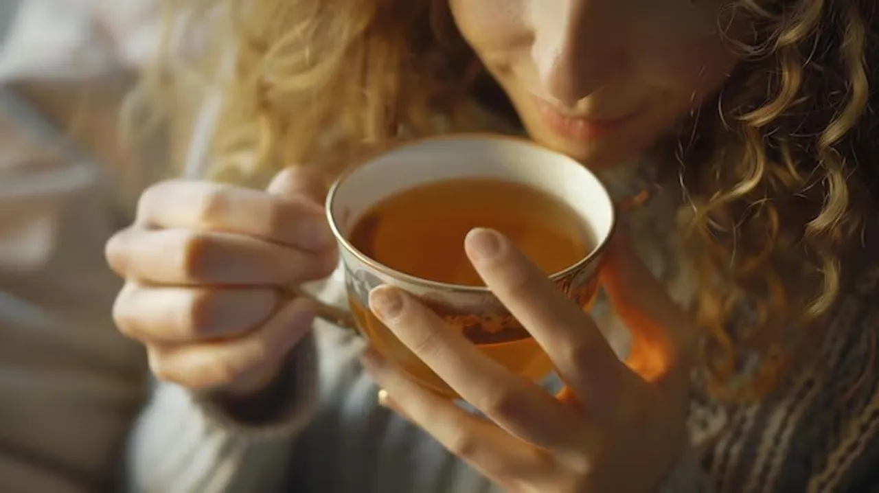 close-up-woman-drinking-tea-from-delicate-cup_14117-874011