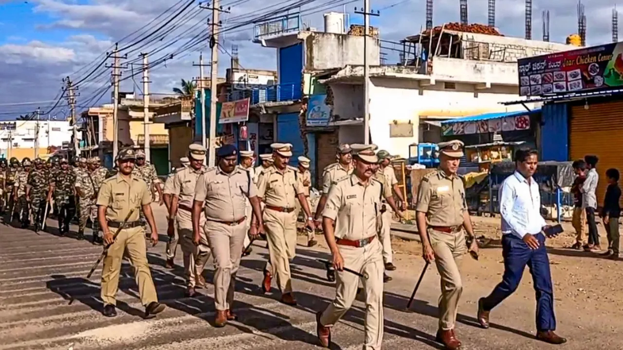 Police conduct a march following clashes between two groups allegedly during a Ganpati procession, in Nagamangala town of Karnataka's Mandya district, Thursday, Sept. 12, 2024.