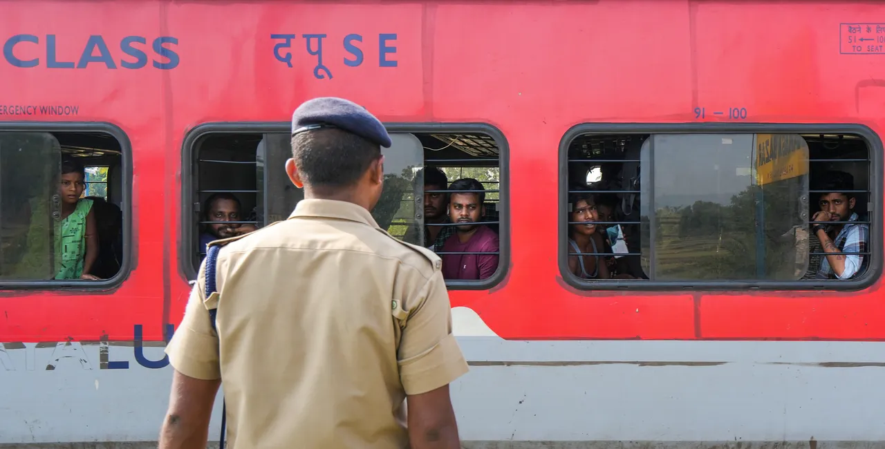 An RPF personnel keeps watch as Coromandel Express train leaves from Bahanaga Bazar railway station after train services resumed