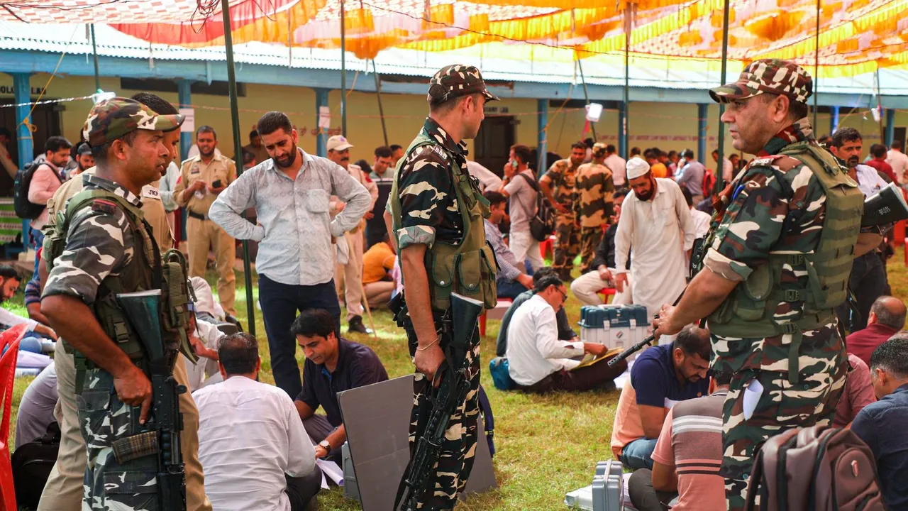 Security personnel keep vigil as polling officials check EVMs and other election material before leaving for their respective polling stations for the second phase of J & K Assembly polls, in Nowshera area of Rajouri district, J&K, Tuesday, Sept. 24, 2024.