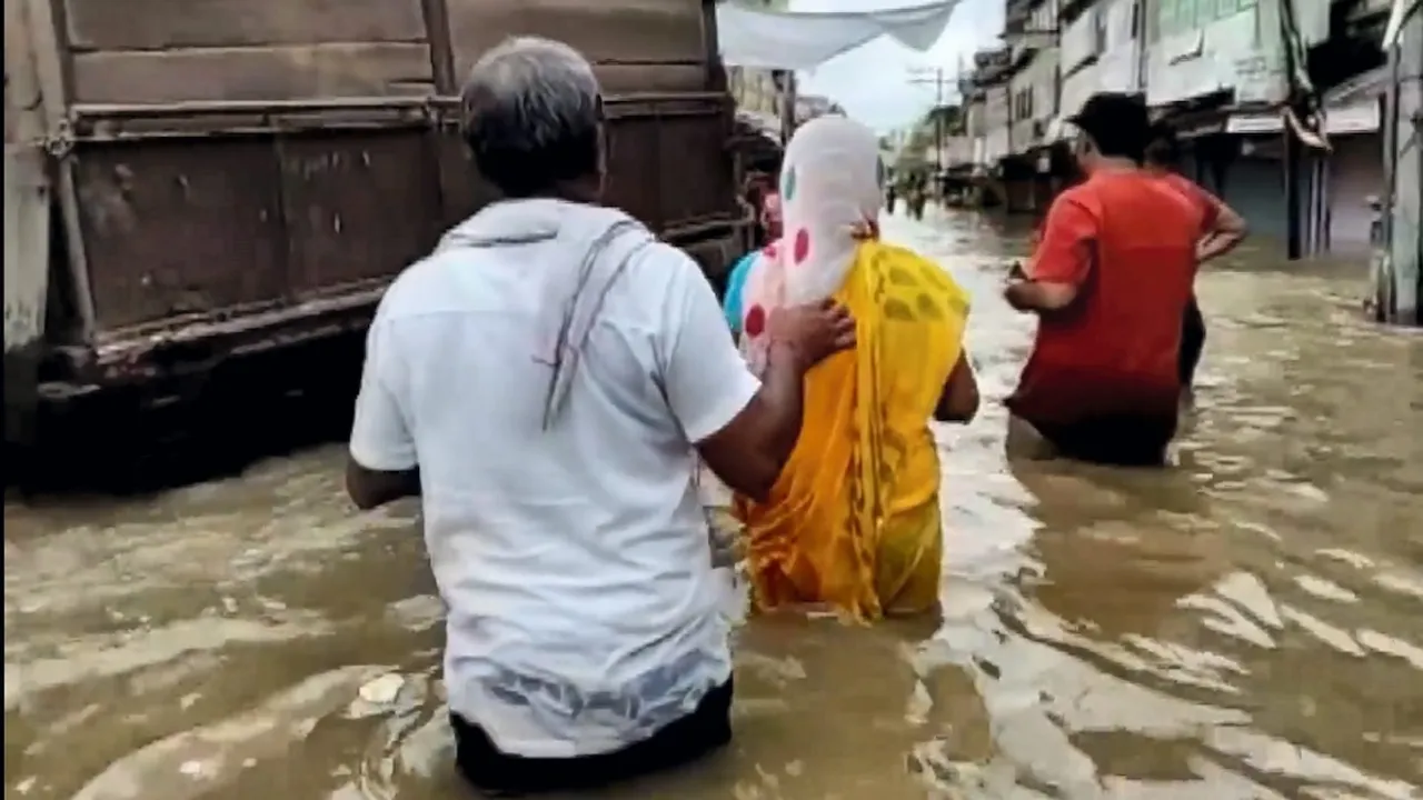 People pass through a waterlogged area after heavy rainfall, in Hindaun city, Rajasthan, Sunday, Aug. 11, 2024.