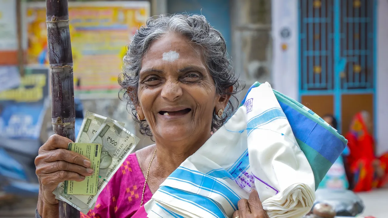 A beneficiary poses for photos after receiving Pongal gift hamper at the Vadaserry ration shop, in Nagercoil