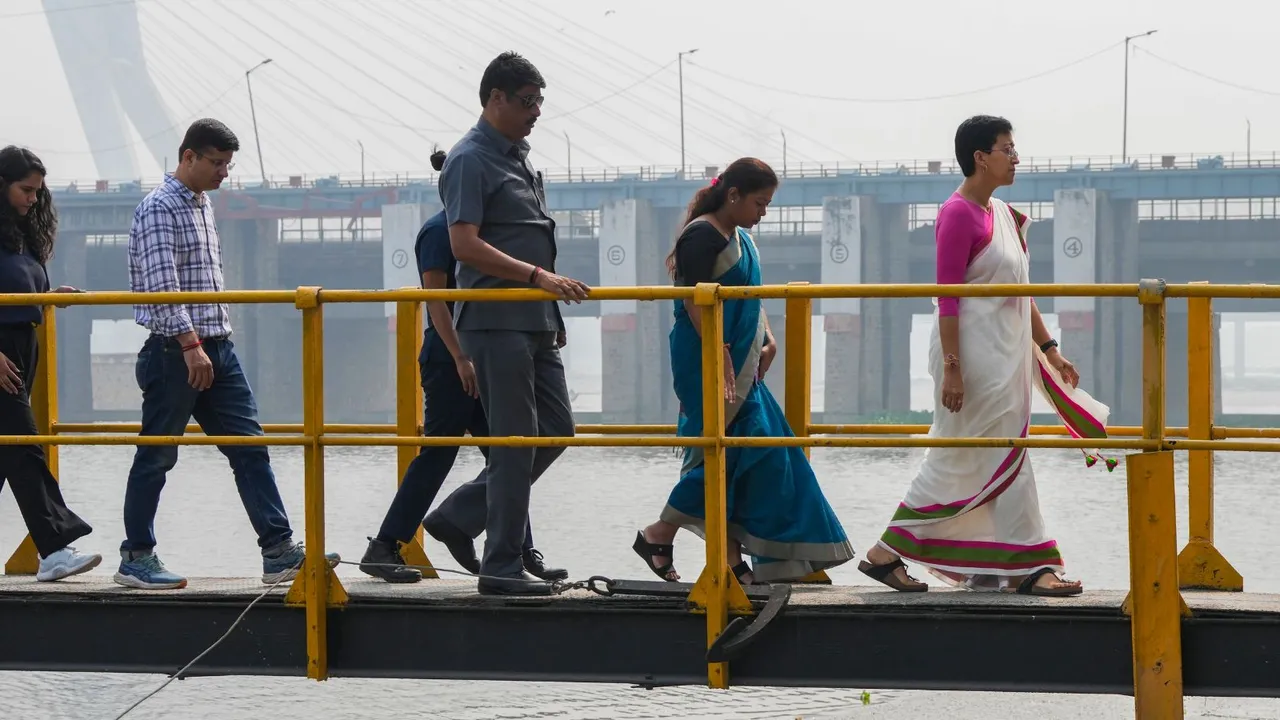 Delhi Chief Minister Atishi with others during an inspection at the Wazirabad barrage amid pollution in the Yamuna river, in New Delhi, Wednesday, Oct. 23, 2024.