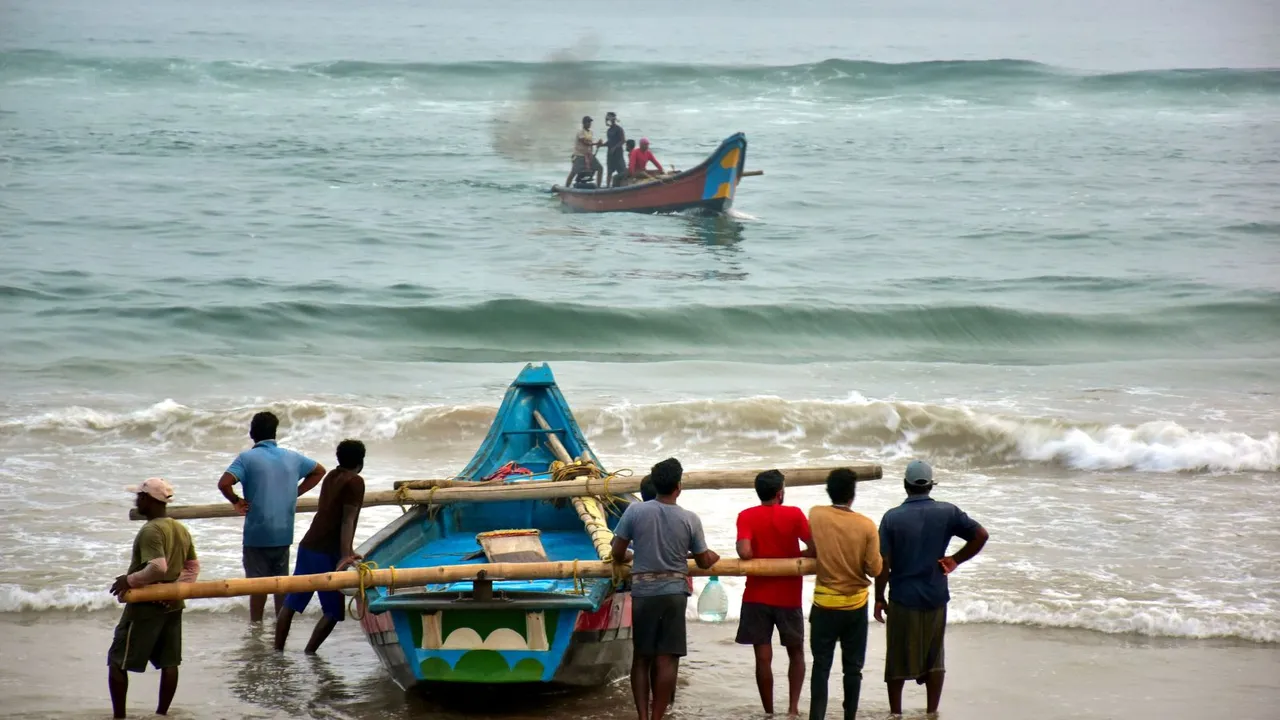 Fishermen shift their boats in preparations for Cyclone Dana, in Puri